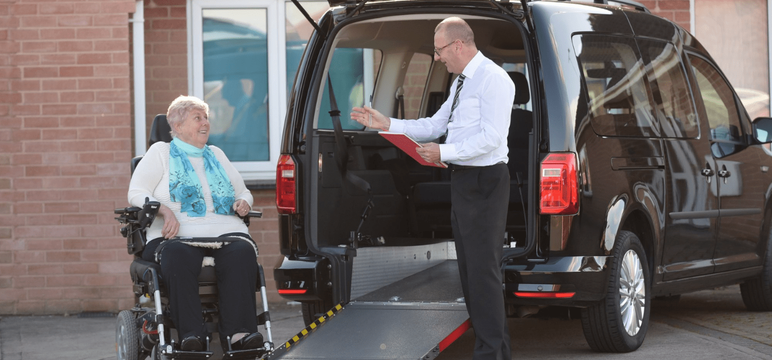 Professional NEMT driver helping a wheelchair user safely board a transport vehicle in Baton Rouge.